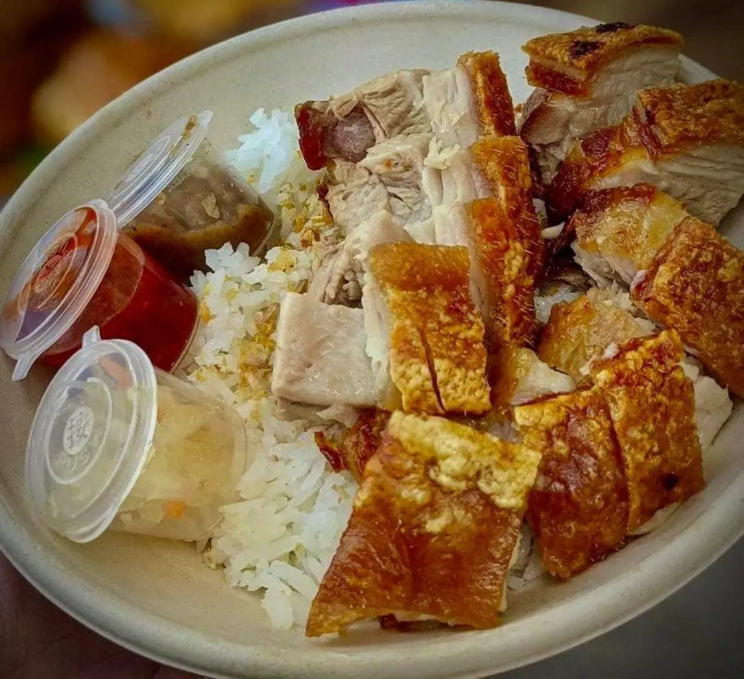 plate of crispy bagnet over rice with three side sauces