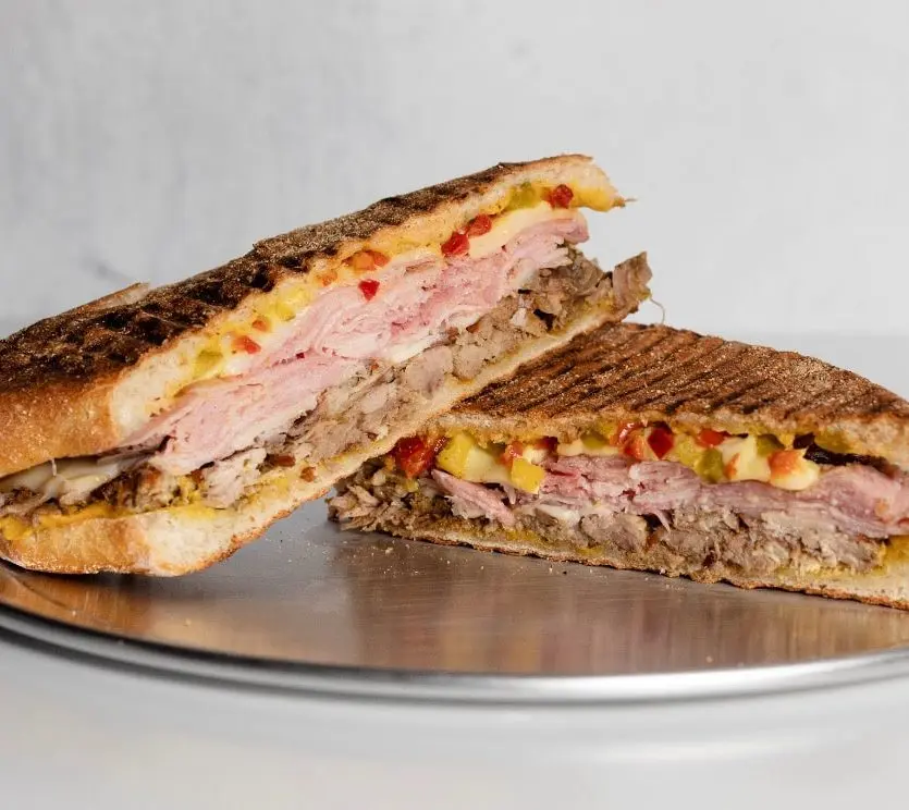 TONY CUBANO made with pulled pork, Tuscan ham, black garlic sofrito mustard, swiss, and pickles
