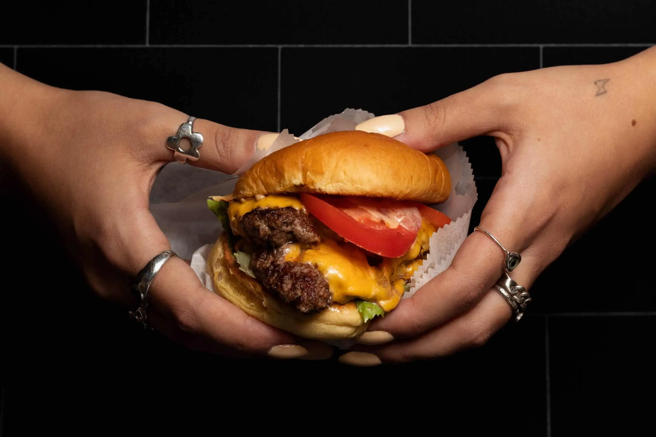 THE AMERICAN BURGER made with double smashed patty, iceberg lettuce, roma tomatoes, American cheese, and Fatty's sauce.