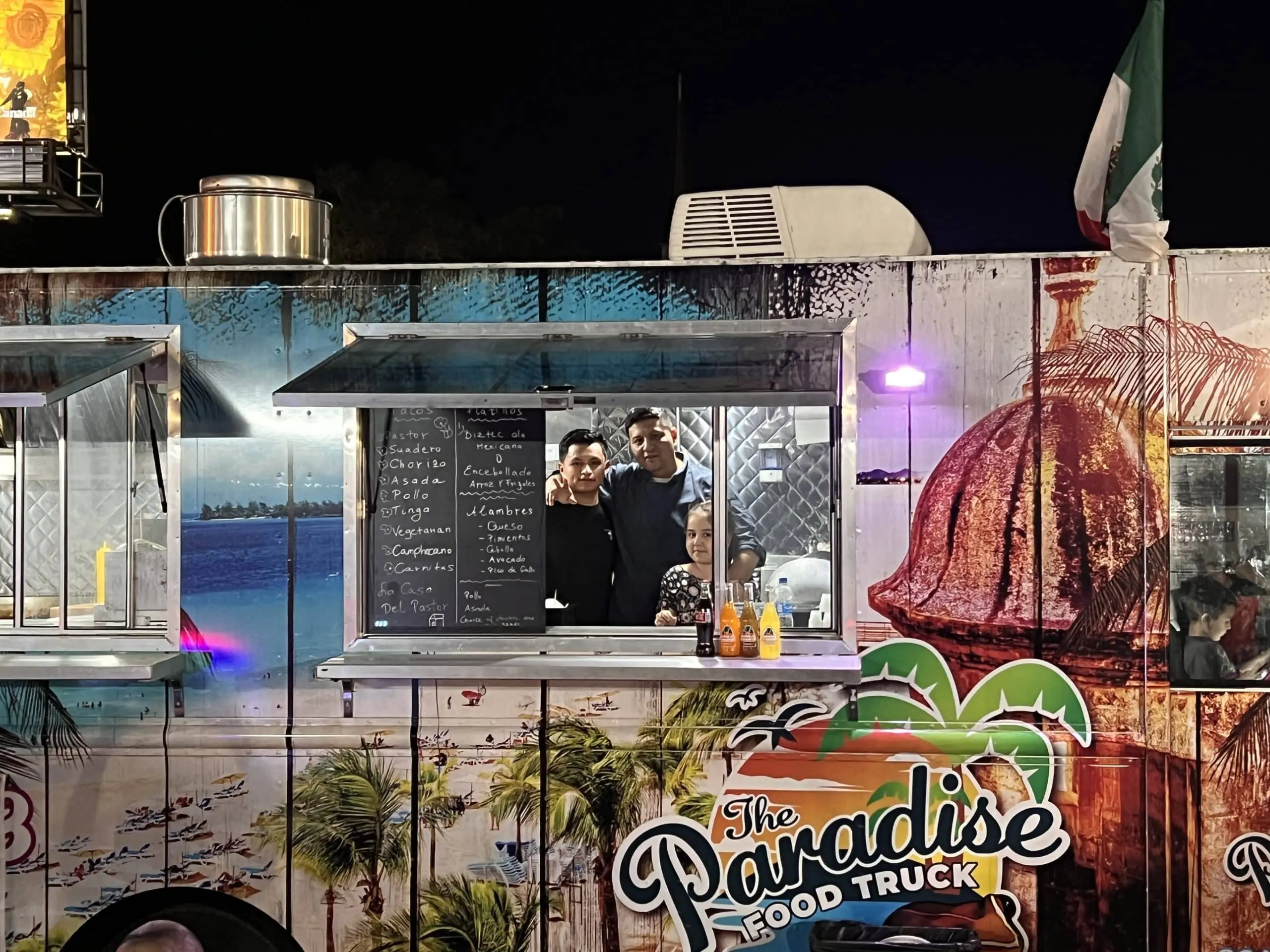 view of paradise food truck with the owners