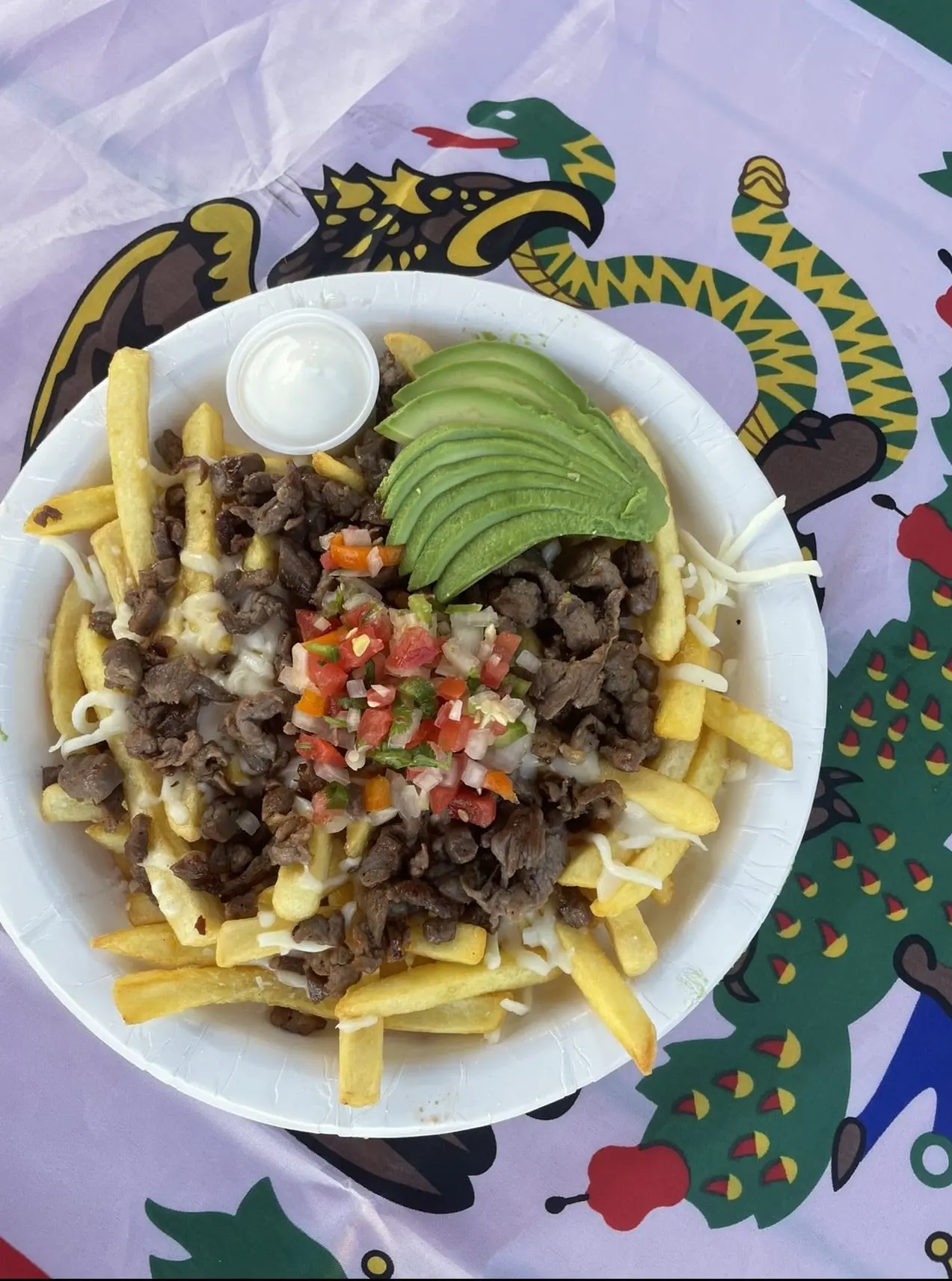 a plate of loaded nacho fries with avocado