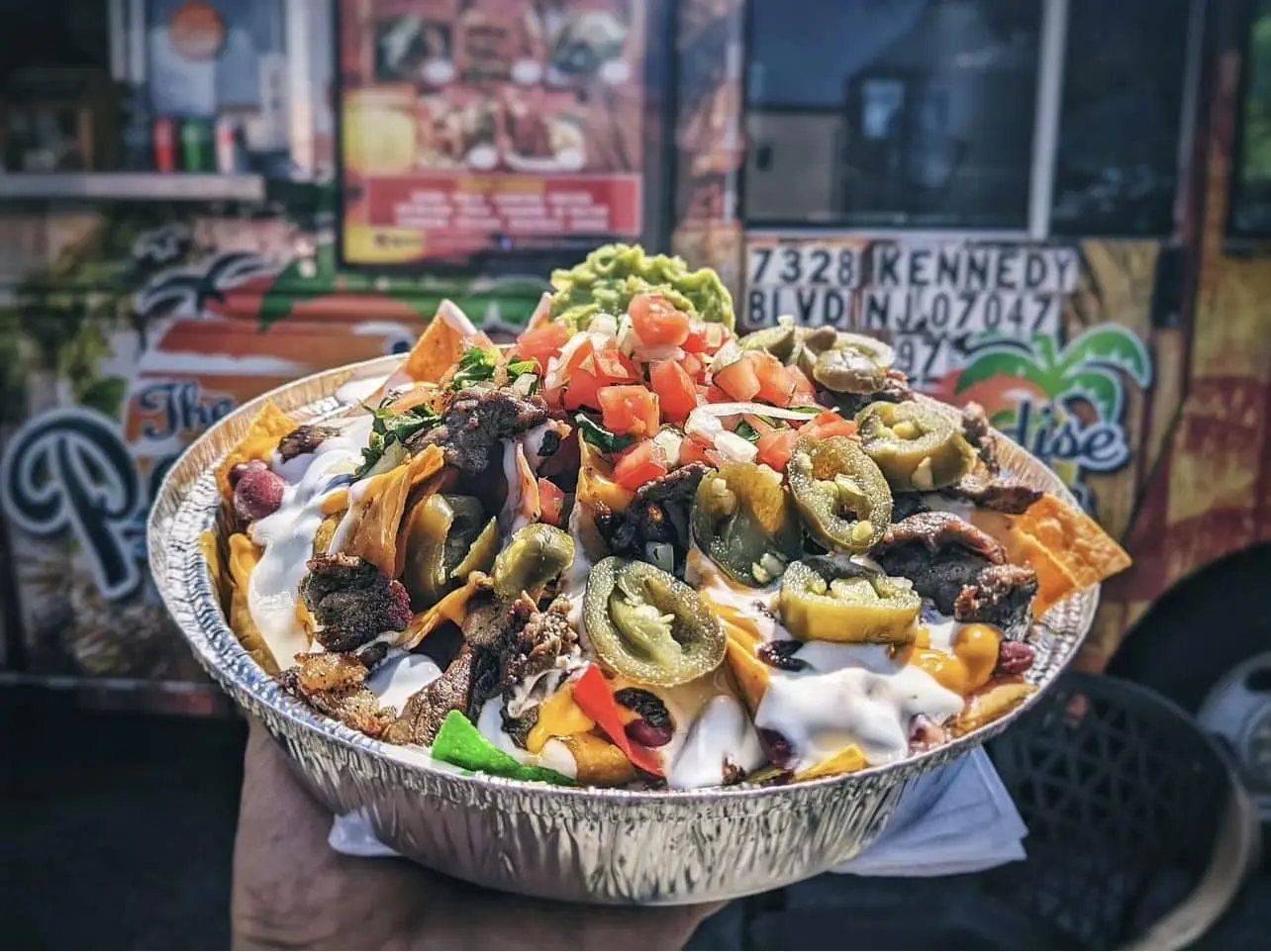 close up of loaded nachos with meat and guacamole